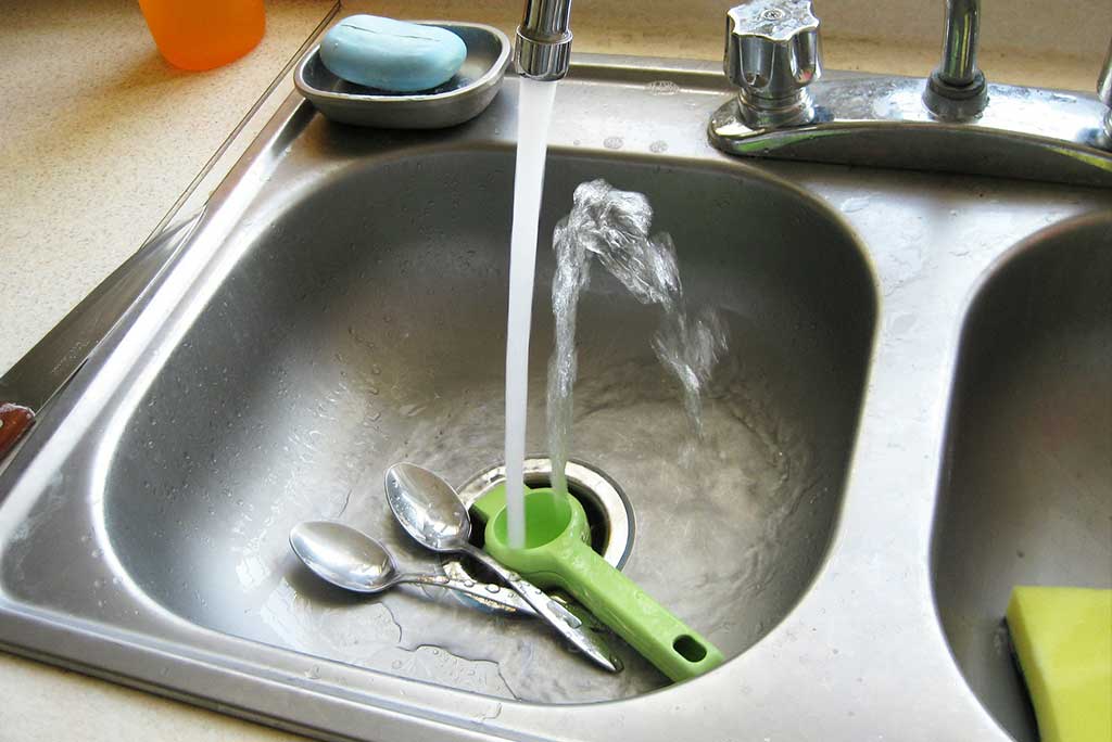 Kitchen sink garbage disposal with running water