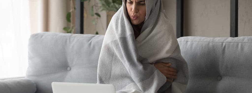 Woman wrapped in blanket in a cold home