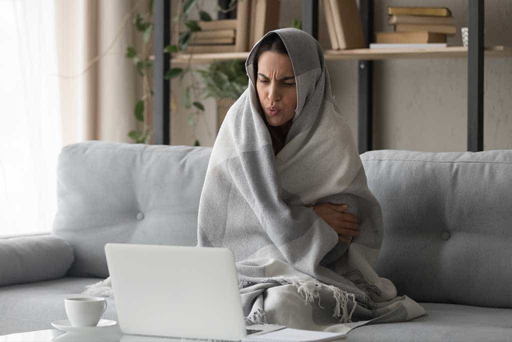 Woman wrapped in blanket in a cold home